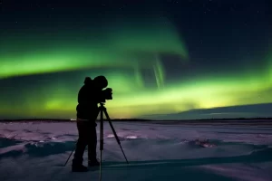 man taking picture of northern lights at night with camera 1024x683 1